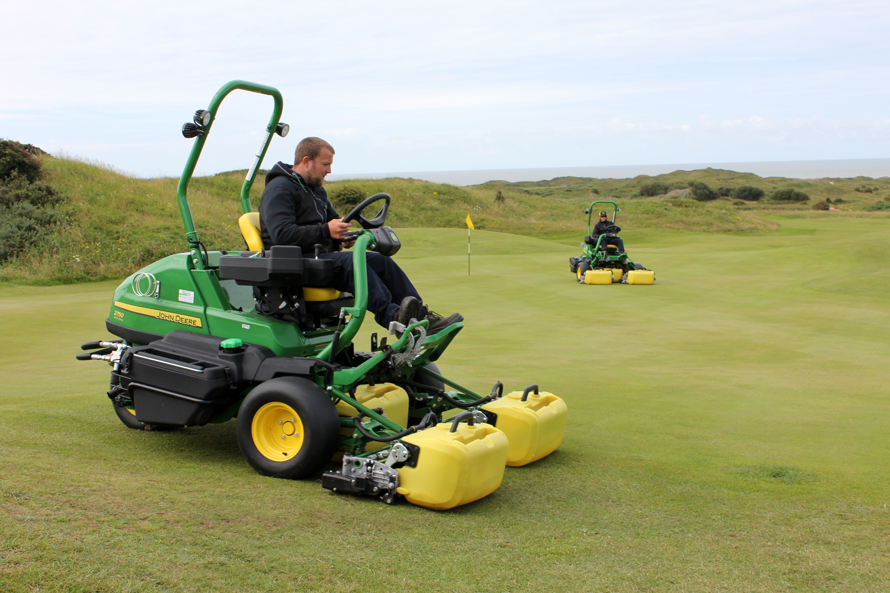 Simon Lacey and Stephen Lambert operating the new John Deere 2750E hybrid electric mowers on Pyle & Kenfig’s 14th green.